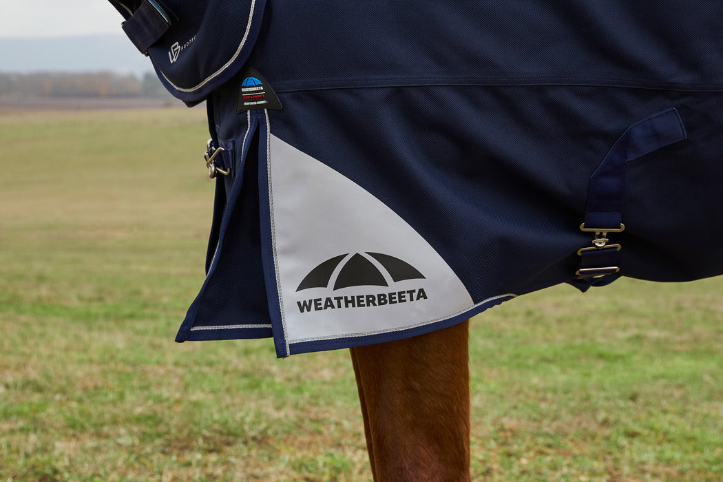 Navy horse blanket with Weatherbeeta logo on a grassy field